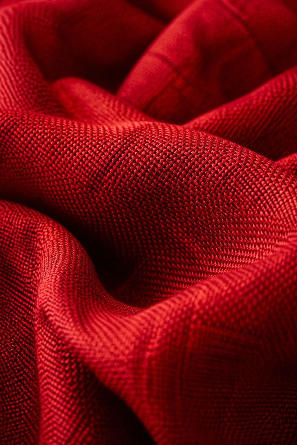Extreme close-up of vivid red fabric texture in natural light.