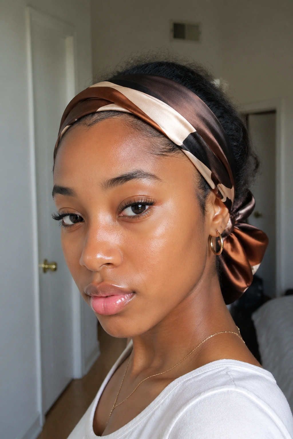Real person wearing a satin scarf styled around the hairline