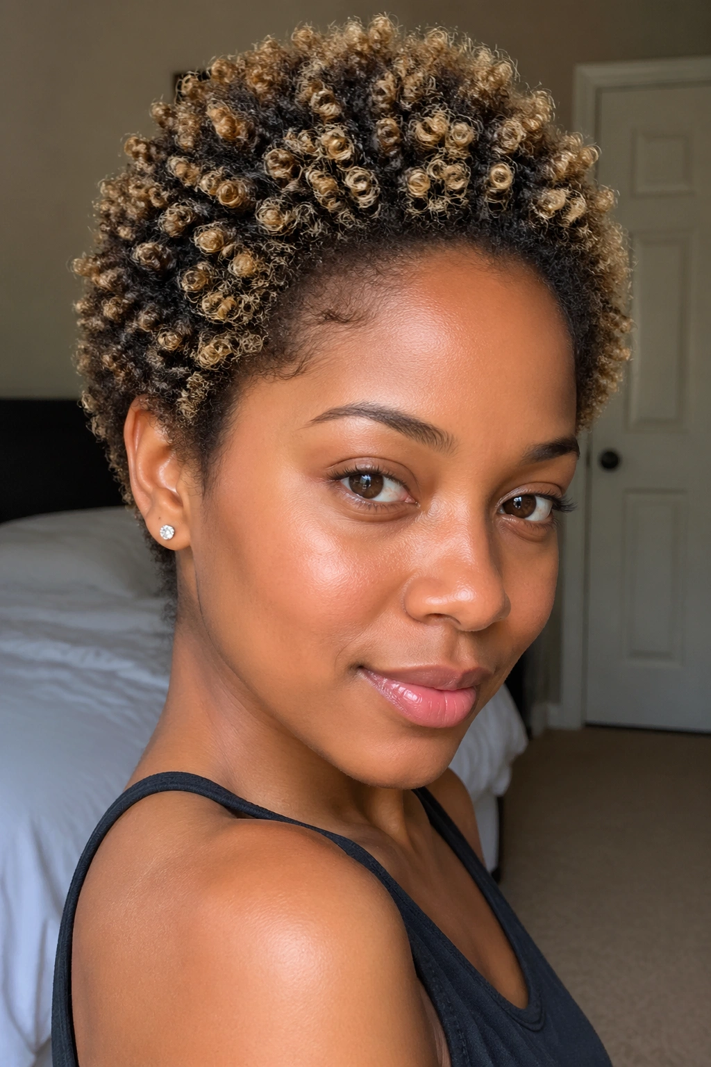 Close-up of short natural hair with blonde highlights at coil tips