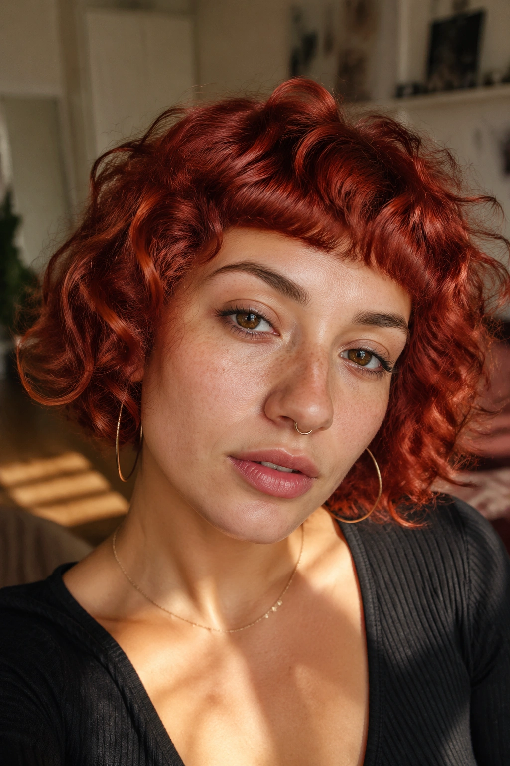 Close-up of a short red curly bob with micro bangs on a real woman