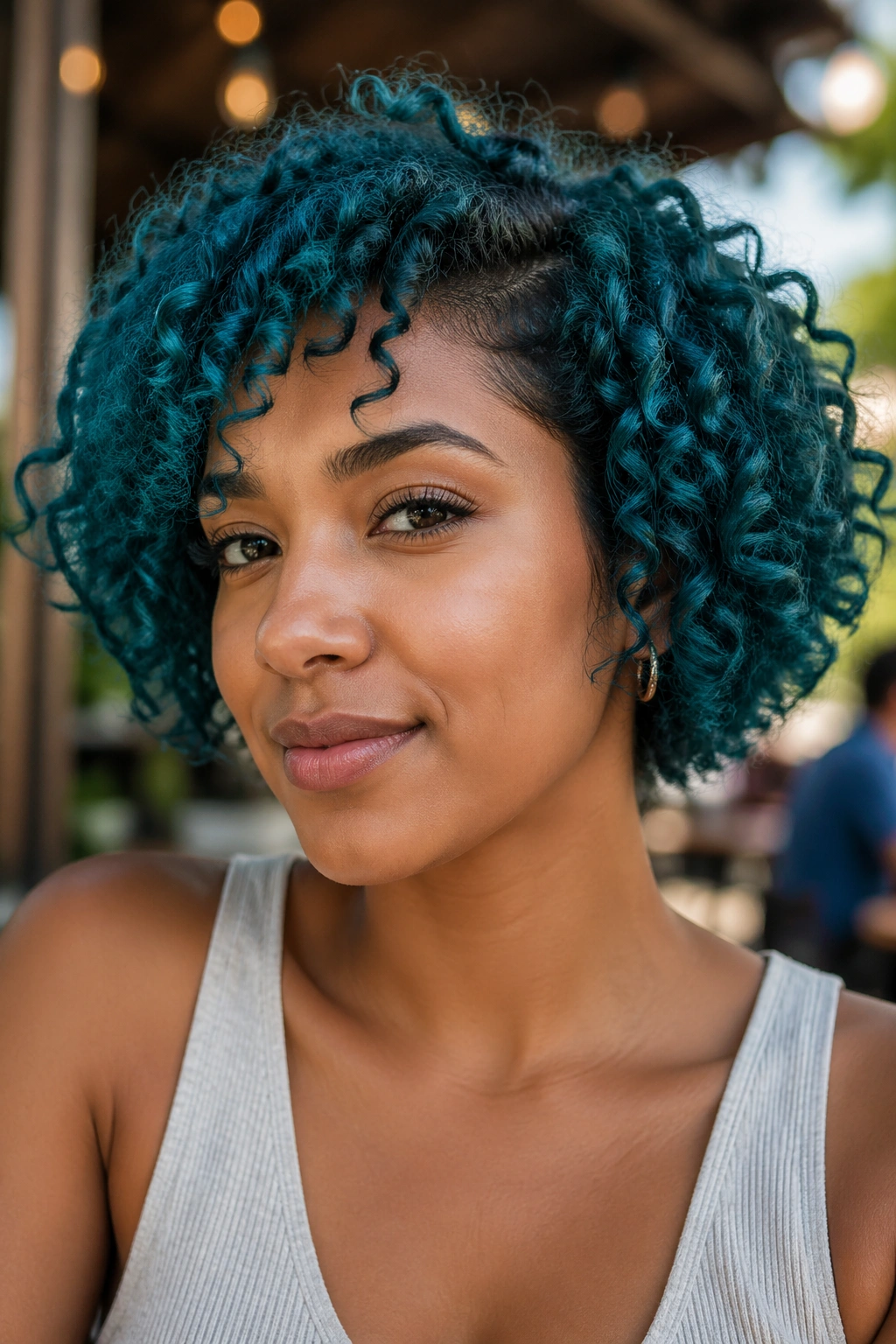 Close-up of a real person with teal short curly bob hairstyle