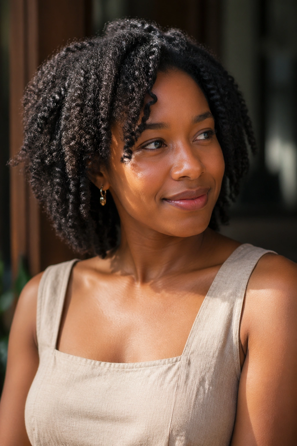 Portrait of a person with a defined twist-out hairstyle wearing a linen dress.