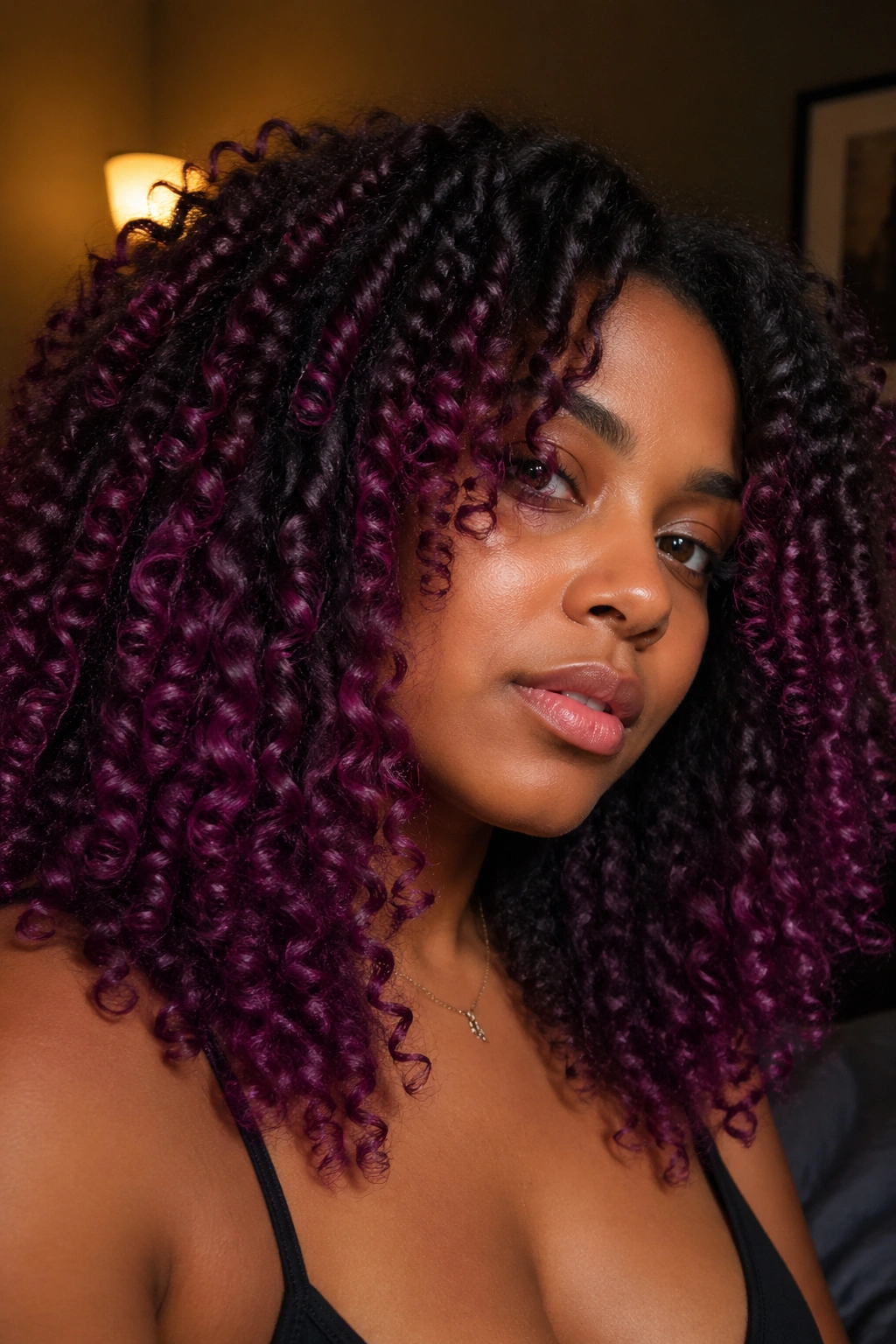 Thick 4A curls with wine to purple gradient under warm light.